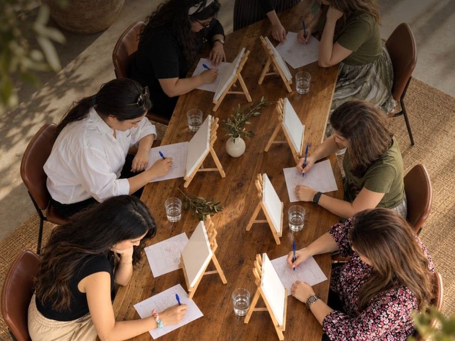 A team drawing together around a wooden table