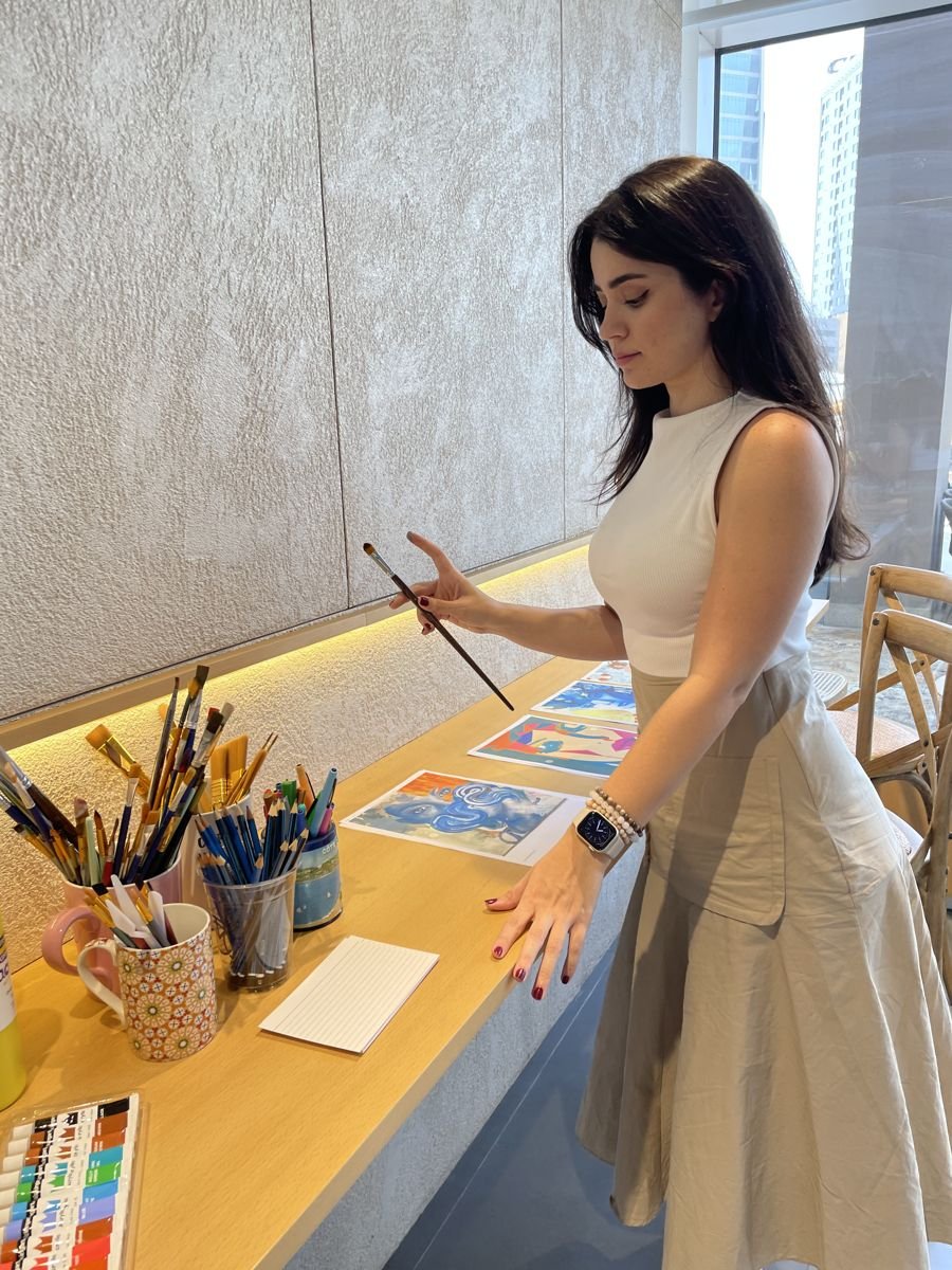 Senamees laying out her paintings in the studio